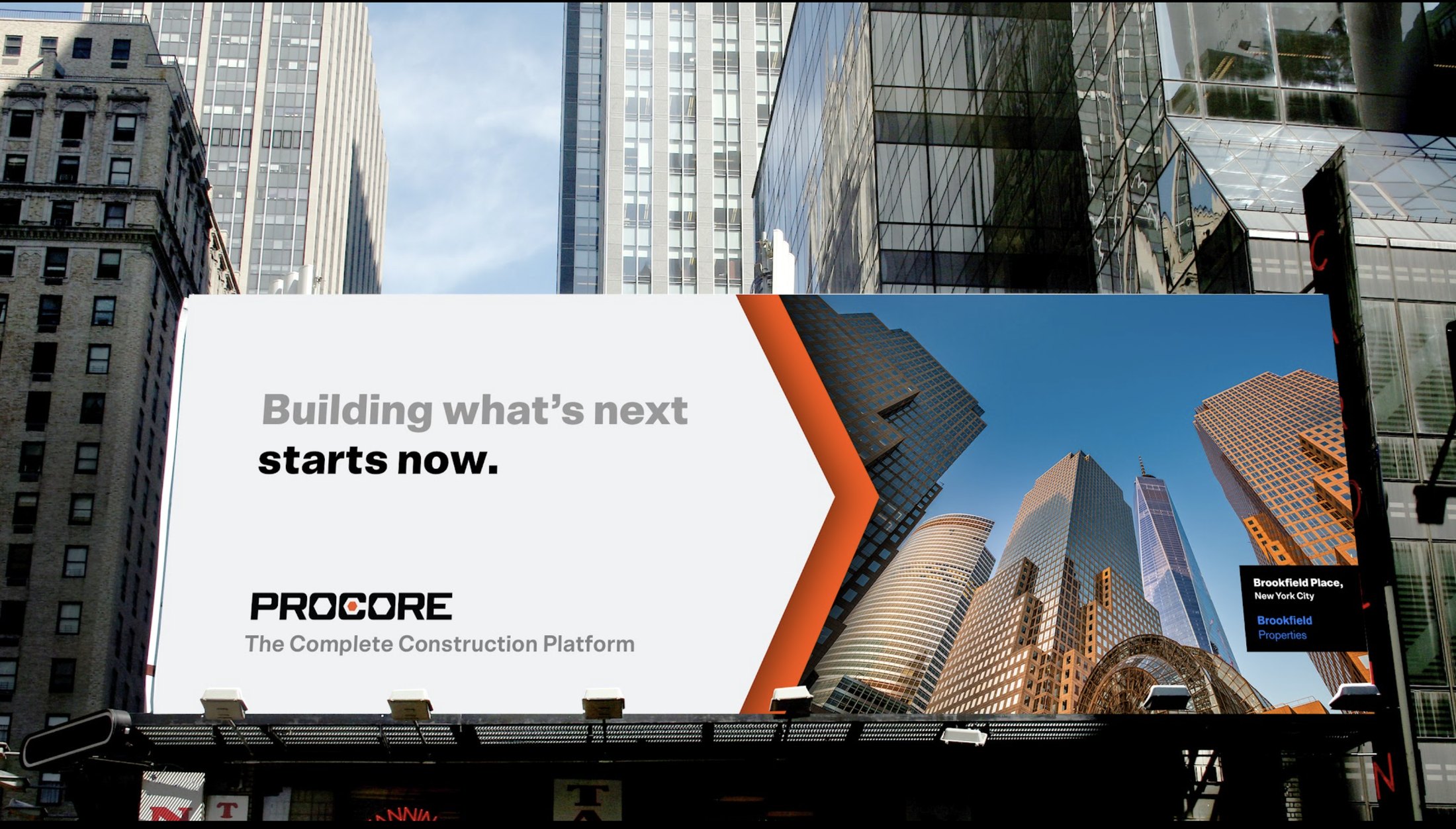 Procore campaign running on a large digital billboard above a Manhattan street, reading 'Building what's next starts now' beside a photograph of the Brookfield Place towers.