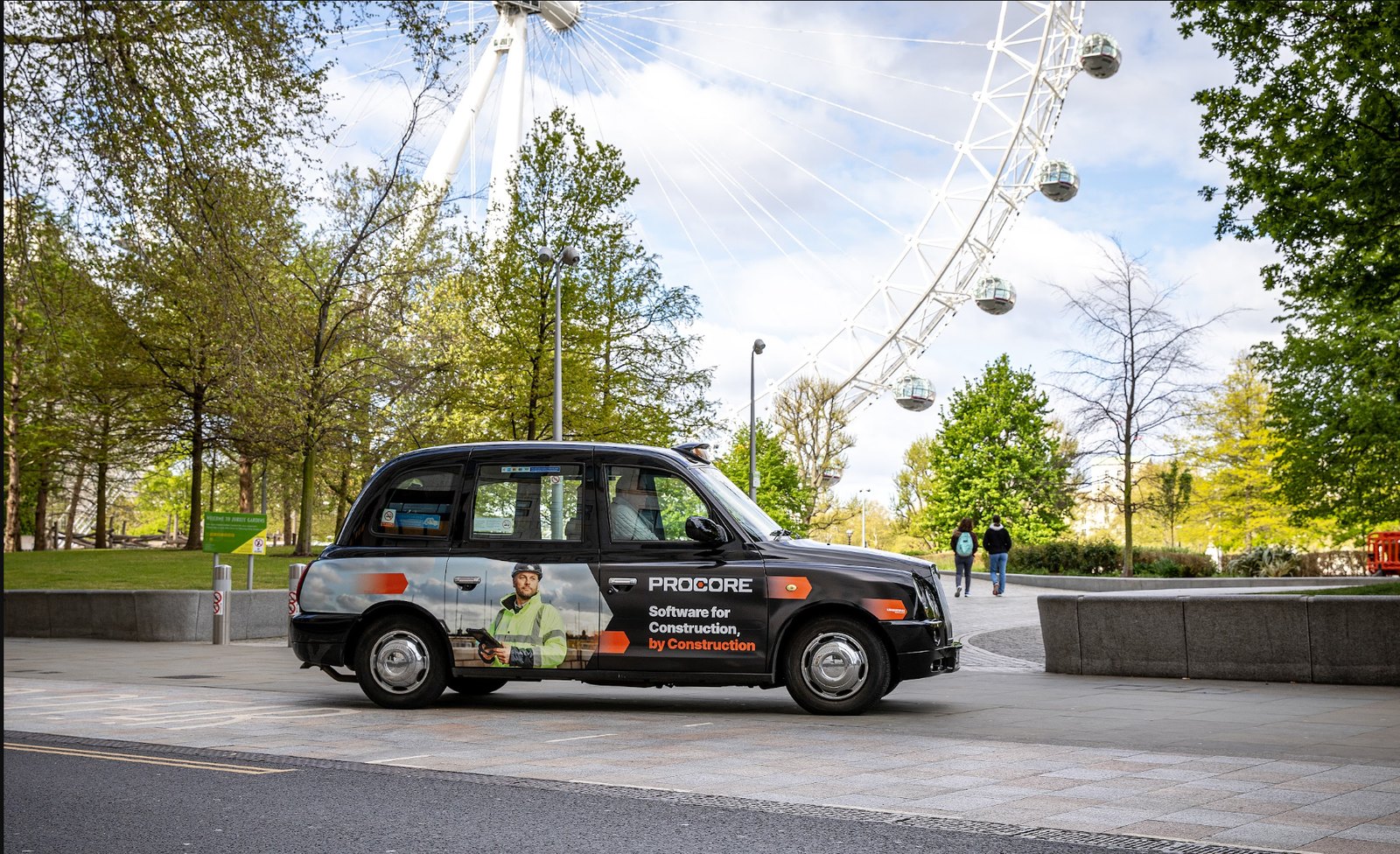 Procore-wrapped black cab driving past the London Eye on the South Bank.